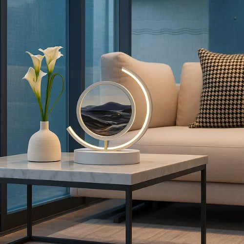 Black sand art LED lamp on a marble coffee table in a modern living room – ambient lighting and contemporary home decoration